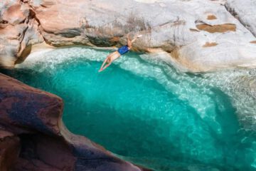 Man Jumping into Turquoise Waters of Paradise Valley - Exhilarating moment amidst the stunning natural scenery