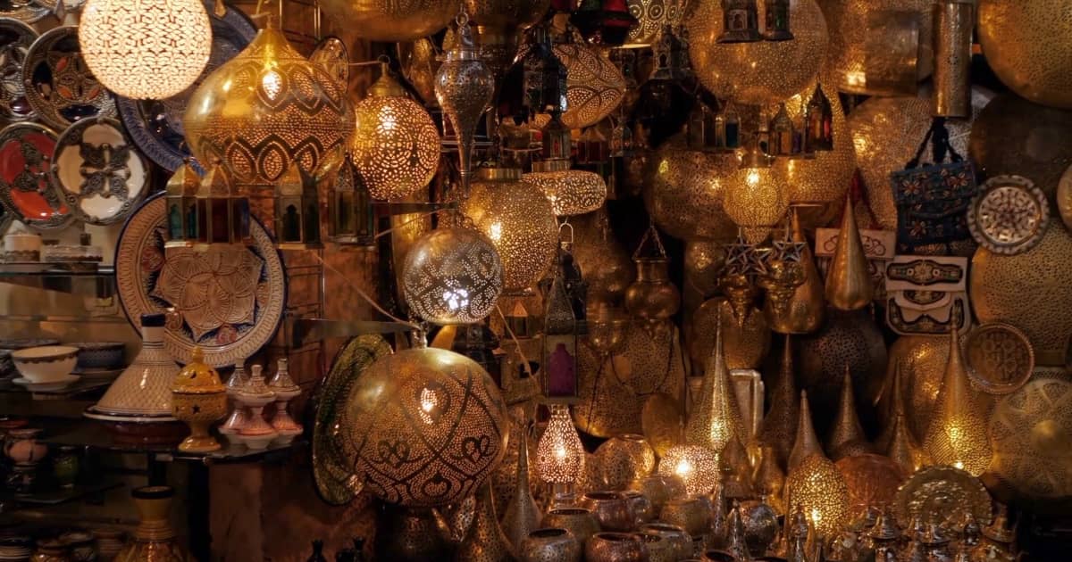 Kupferwaren in den Souks von Marrakesch – Traditionelles Handwerk erleben Kupferwaren und traditionelle Handwerkskunst in den Souks von Marrakesch, glänzende Kupfertöpfe und -lampen auf Marktständen