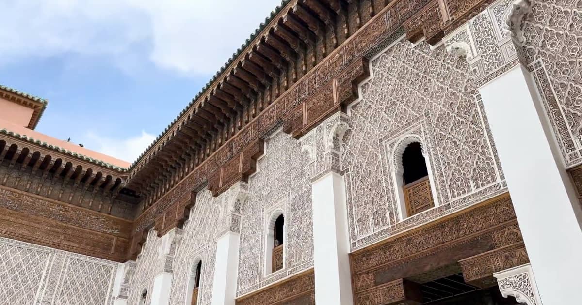Historische Medersa Ben Youssef in Marrakesch mit kunstvollen Verzierungen, traditioneller islamischer Architektur und einem beeindruckenden Innenhof.
