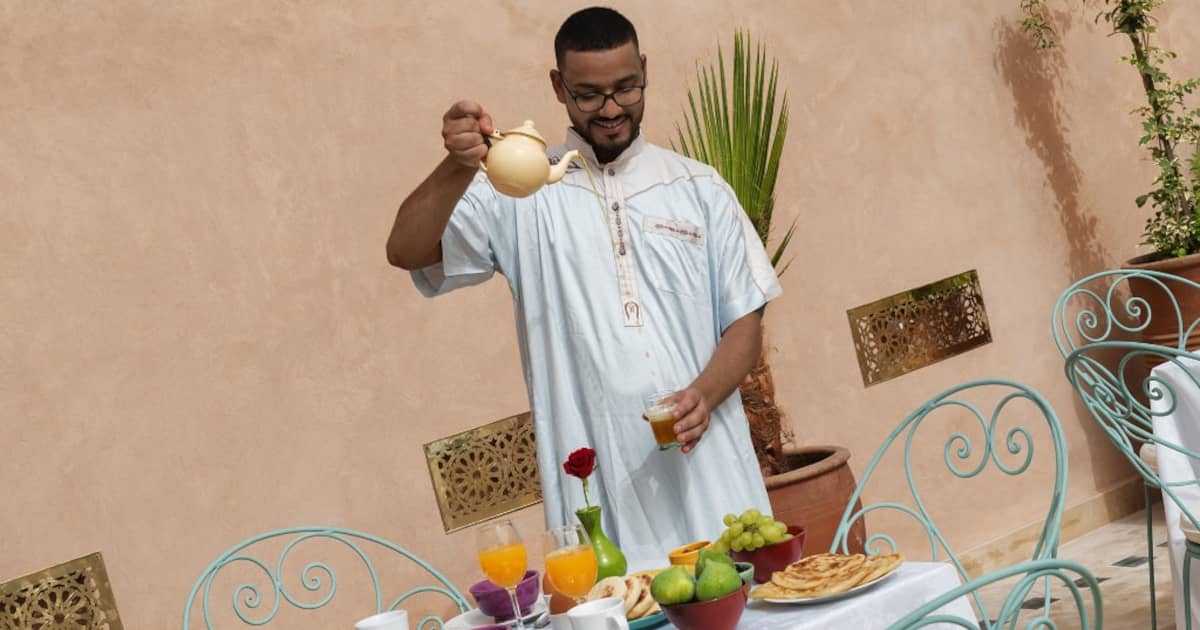 Traditionell servierter marokkanischer Minztee auf einer Riad-Terrasse mit Blick auf die Stadt