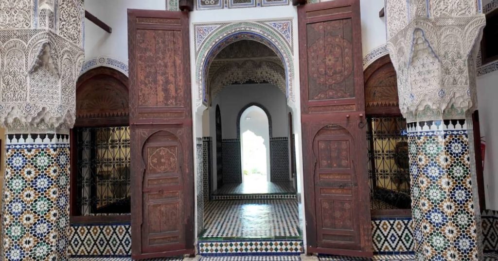 Innenhof des Dar Jamaï Museums in Meknes Marokko mit kunstvoller Mosaikarchitektur und traditionellen Holzdetails