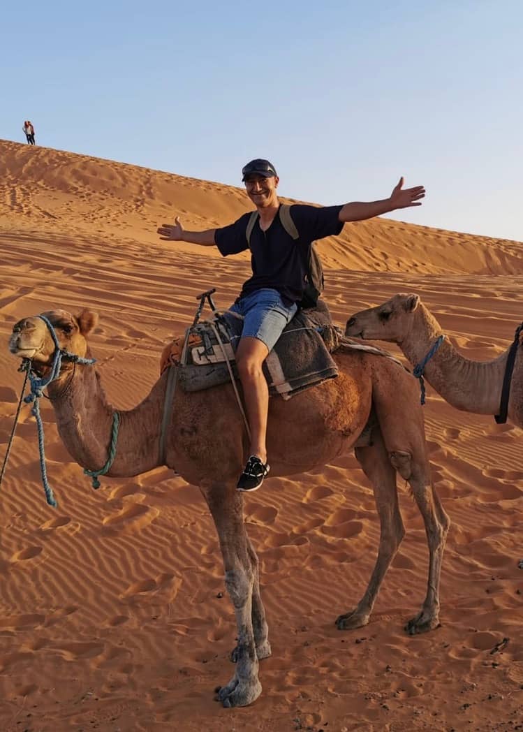 Stylia Tours founder, Hassane Assou, on a camel trek through the Moroccan desert