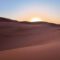 Explore Moroccan desert Merzouga sunset over sand dunes.