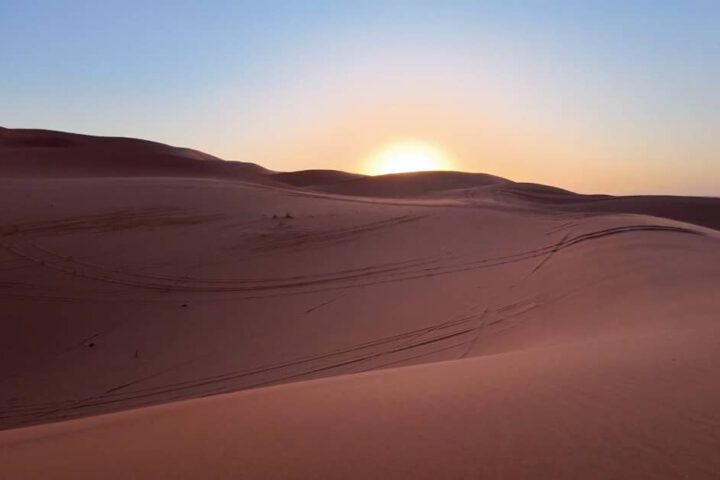 Explore Moroccan desert Merzouga sunset over sand dunes.