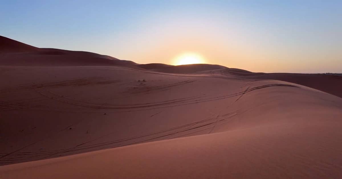 Explore Moroccan desert Merzouga sunset over sand dunes.