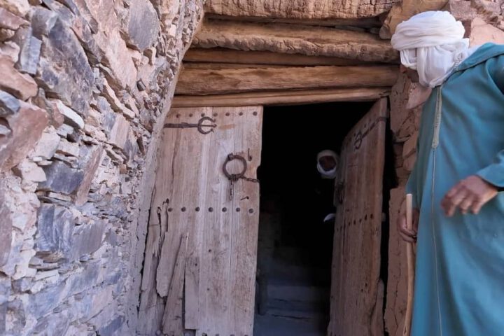 Local guide in Amtoudi explaining the ancient agadir to visitors.