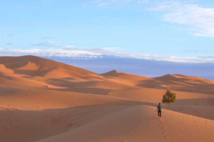 Weite Dünenlandschaft der Merzouga Wüste mit Wanderer in Erg Chebbi