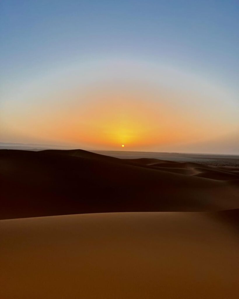 Sanddünen der Sahara in Marokko mit weitem Horizont bei Sonnenaufgang