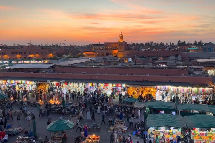 View over the rooftops of Marrakech with sunset light glowing above Djemaa El Fna square