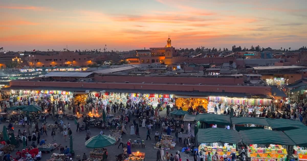 View over the rooftops of Marrakech with sunset light glowing above Djemaa El Fna square