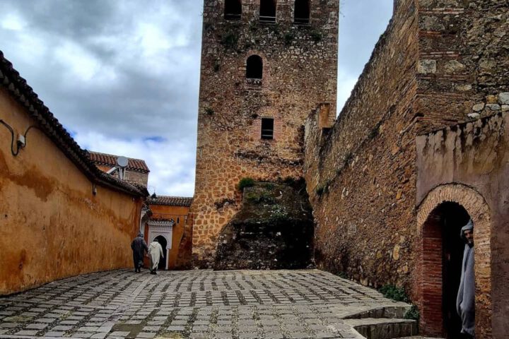 The historic red-walled Kasbah fortress of Chefchaouen surrounded by the iconic blue buildings of the Medina.