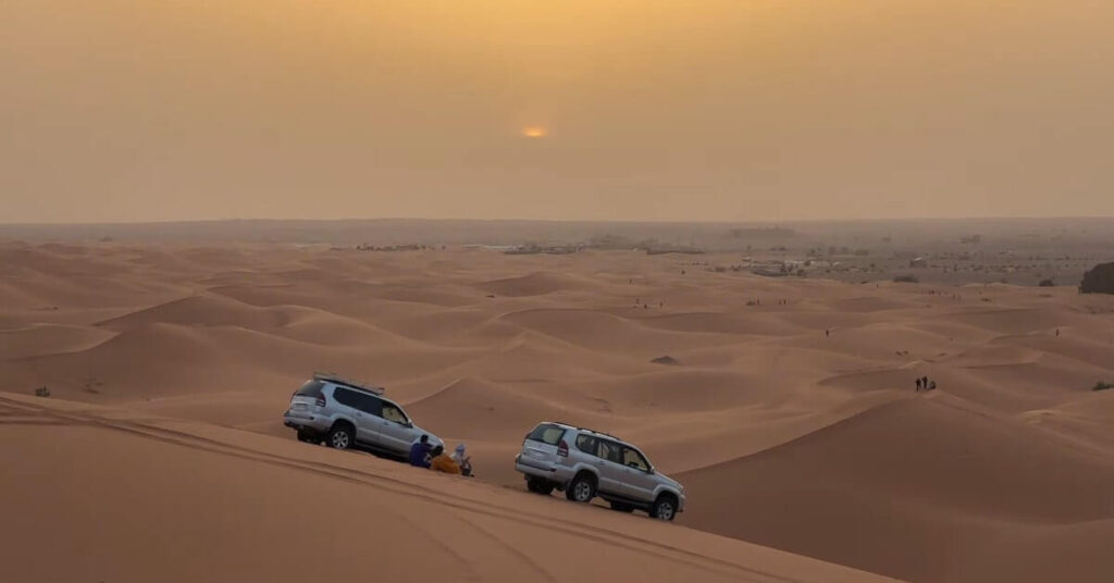 4x4 off-road vehicle driving through the golden sand dunes of Merzouga from Agadir.