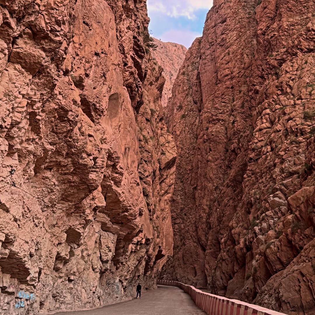 Towering red rock formations and winding river at the entrance of the Dades Gorge, a highlight of Day 1 on the Marrakech to Merzouga tour.