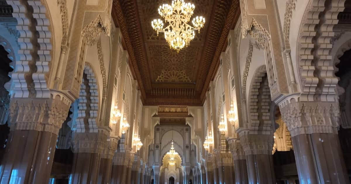 Prachtvoller Innenraum der Hassan-II.-Moschee in Casablanca mit kunstvollen Deckenverzierungen und Kronleuchtern.