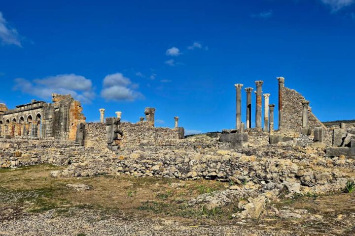Ancient Roman ruins of Volubilis in Morocco with stone columns and panoramic views.