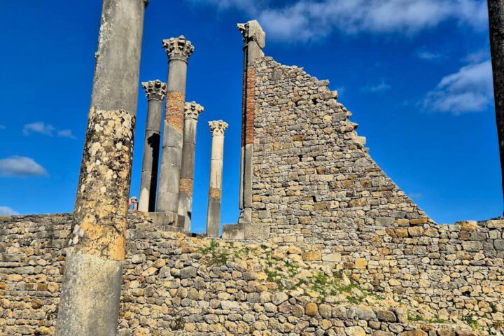 Roman temple columns and stone wall ruins at Volubilis in Morocco.