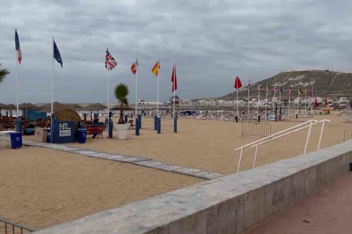 Strandbereich in Agadir mit internationalen Flaggen, Sitzbereichen und Blick auf die Küste