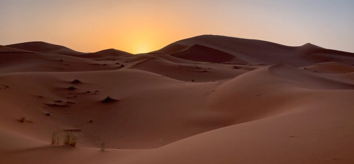 Sunset over Sahara desert dunes in Morocco during a private tour
